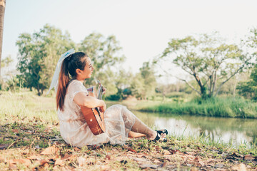Girl playing guitar in the forest. Music hobby and picnic concept.