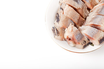 Salted herring on oval plate on a light background . Marinated sliced fish. Traditional russian appetizer