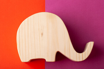 Elephant figurine carved from solid pine by hand jigsaw. On a multi-colored background