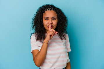 Young african american woman isolated on blue background keeping a secret or asking for silence.