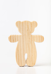 A figurine of a toy bear, cut out of solid pine by a hand-held jigsaw. On a white background