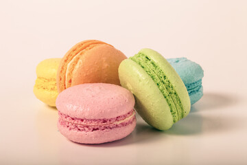 Colorful cake macaroons on a light background. Toned