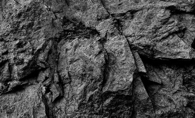 The texture of the stone is black.  Close-up of the rough texture of a large stone.  Stone surface for natural background.  Close-up of blurred stone background texture