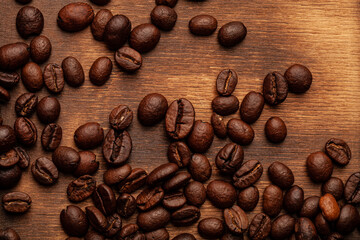 Roasted coffee beans on the old dark wooden background for wallpaper or decor
