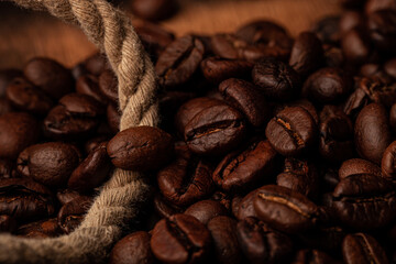 Roasted coffee beans on the old dark wooden background for wallpaper or decor
