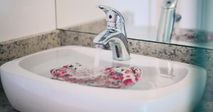 Clogged and overfilled bathroom sink with running water