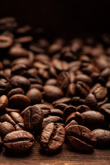 Roasted coffee beans on the old dark wooden background for wallpaper or decor