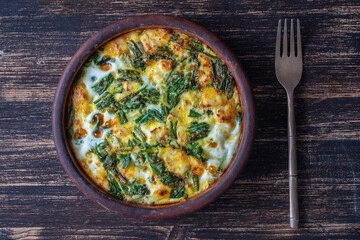 Ceramic bowl with vegetable frittata, simple vegetarian food. Frittata with egg, pepper, onion,...