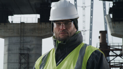 Serious bridge builder looking at camera