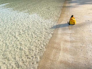 Obraz premium Beach and sea texture and background with blurry vivid yellow waterproof bag. Summer or travel concept and idea.