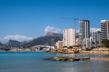 Some views to Calpe beach and Serra Gelada mountain, with buildings and yachts, in a sunny day.