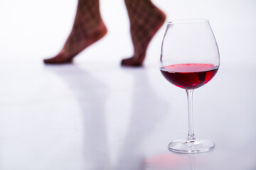 red wine in a glass. Sexy legs woman. Erotica. 