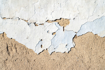 Old plastered wall background. Texture old peeling potreskanoy, weathered stucco chipped and cracked. Collapsing clay wall. Destructive influence of time and environment. Texture background