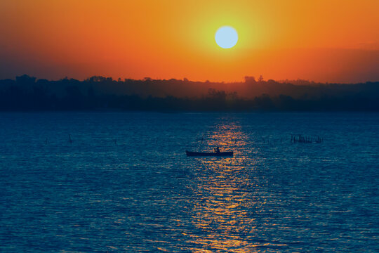 African Sunset. Man Is Rowing On A Boat In A Bay In Dar Es Salaam,Tanzania.