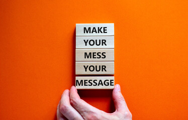 Business concept growth success process. Wood blocks on orange background, copy space. Businessman hand. Words 'make your mess your message'. Conceptual image of motivation.