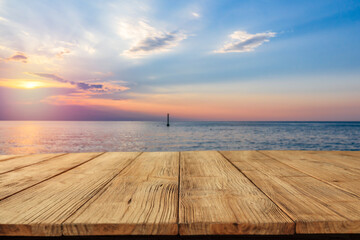 Sunset on the seashore and wooden table in the evening 
