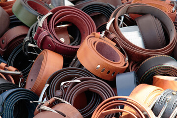 leather belts rolled and piled in bulk