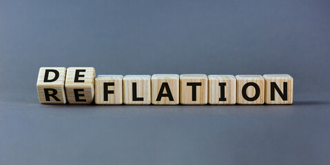 Deflation or reflation symbol. Turned cubes and changed the word deflation to reflation. Beautiful grey background, copy space. Business, deflation or reflation concept.