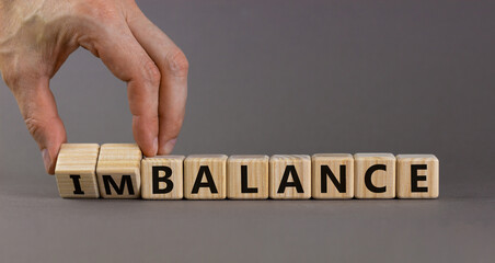 Balance or imbalance symbol. Businessman turns cubes and changes the word imbalance to balance....