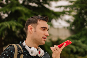 A young Hispanic man talking on his smartphone, on a street outdoors. lifestyle concept.