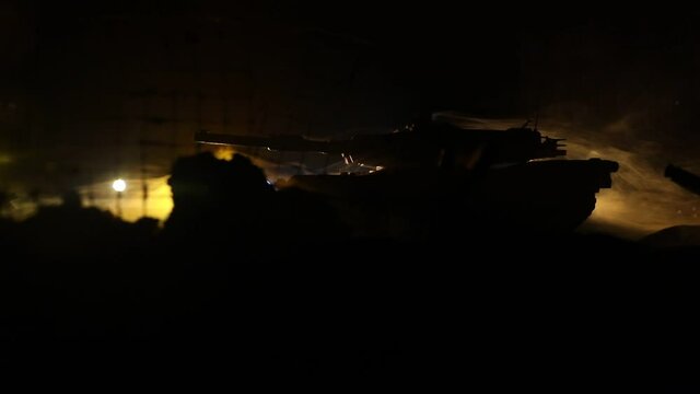 War Concept. Armored vehicle silhouette fighting scene on war foggy sky background at night. American tank moving in destroyed city. Slider shot