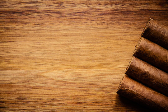 Group of brown cuban cigars on wooden background