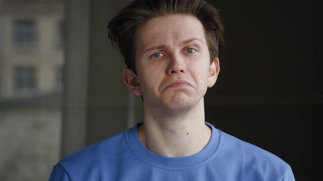 Caucasian guy millennial sad student young man isolated indoors at home looking at camera waving nods head says yes expressing consent support approval, portrait. Close-up male emotional face agrees