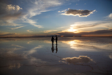 Silhouette of a couple walking on the Salar de Uyuni in Bolivia