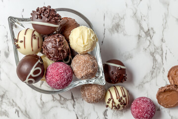 Chocolates candy in a glass vase on a marble table. Cutaway candy, two halves. Close-up. High quality photo