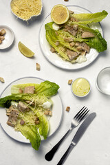 Homemade Caesar Salad with romanine, cheese, croutons, chicken, lemon and sauce