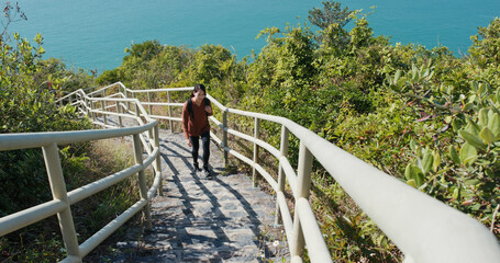 Woman hiking on steps from the sea background