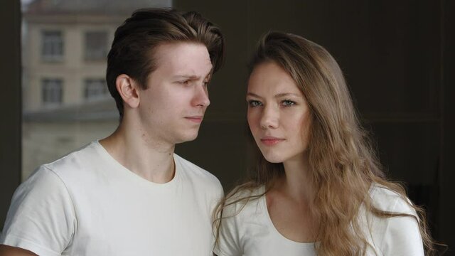 Caucasian newlywed couple friends family boyfriend and girlfriend, husband and wife, man and girl woman questioningly looking at camera asking feeling confused misunderstanding smile, guy winks eye