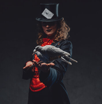 Mystical woman holding a stick with two pigeons in dark background