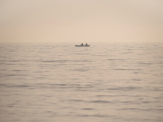 Vintage picture with a small fishing boat on the sea. Lonely boat in the middle of the Black sea