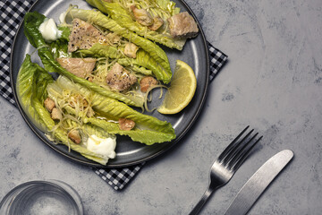 Homemade Caesar Salad with romanine, cheese, croutons, chicken, lemon and sauce