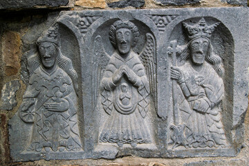 detail of a stone carving of three religious figures
