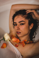 Beautiful sexy lady in elegant white shirt in a bathroom. Fashion portrait of model on a bath indoors.