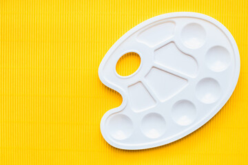 palette for paints, white palette for paints on a yellow background 