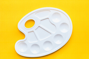 palette for paints, white palette for paints on a yellow background 