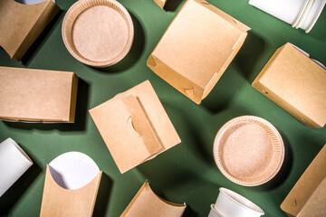 Cardboard fast food and drink packaging concept. Set of various takeaway foods containers on green background, Eco-friendly