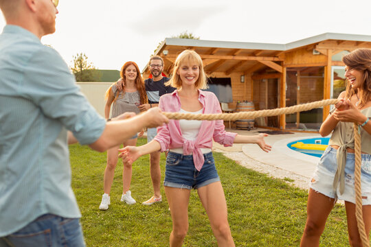 Friends Doing The Limbo Dance At Backyard Party