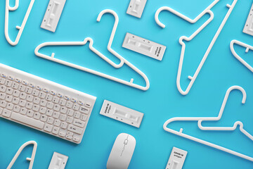 White plastic hangers, keyboard and mouse. Creative top view flat lay on pastel mint blue background, creative minimalism. Top view, concept for sale via social media, online store, shopping online.