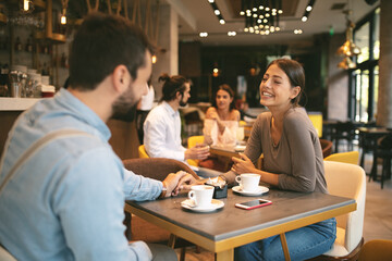 Young happy couple at a date in a coffee shop