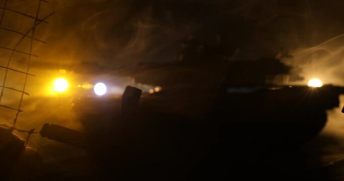 War Concept. Armored vehicle silhouette fighting scene on war foggy sky background at night. American tank moving in destroyed city. Slider shot