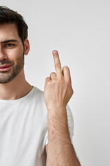 Young man wearing t-shirt showing middle finger