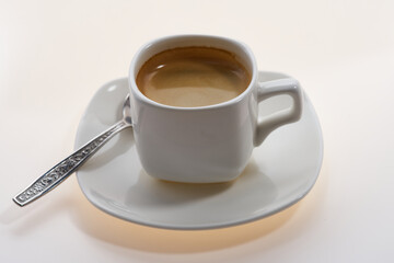 a cup of aromatic espresso coffee on a white glowing background. Selective focus.