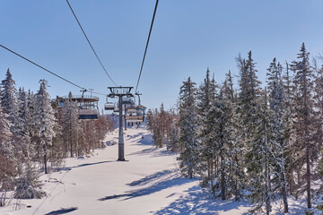Beautiful winter mountain landscape of the Urals region, Russia. Chairlift on the Mount Belaya in foggy weather.