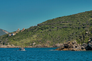 Fototapeta premium paissagem costeira com montanhas, mar, rochas, praias, casas e barcos