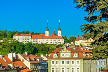 Fototapeta premium Top view to red roofs and green trees skyline of Prague city Czech republic.