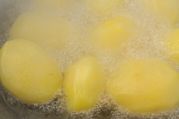 Golden potatoes are fried in boiling oil in a cauldron